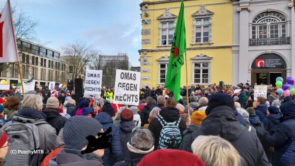 Menschenmenge mit Plakaten und Fahnen